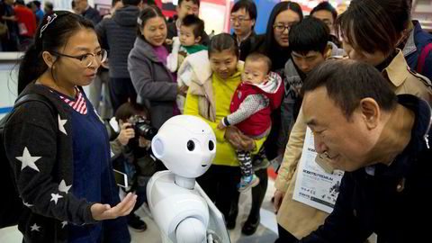 Utfordringen, både ved globalisering og robotisering, er hvordan man kan få den frigjorte arbeidskraften over i annet produktivt arbeid. Her hilser besøkende på World Robot Conference i Beijing på roboten Pepper.